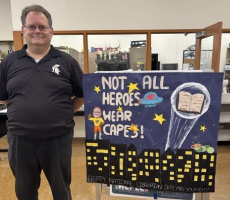  Mr. Young standing by SGA "Happy National Librarian Day" Sign